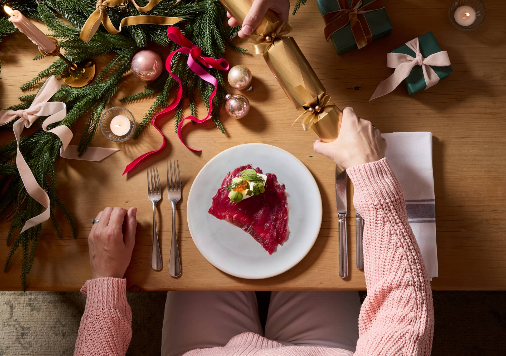 Guests pulling Christmas cracker over Salmon starter